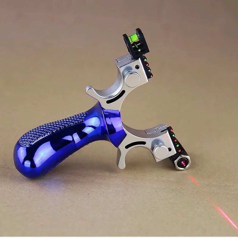 Blue slingshot lying on cardboard with the laser switched on, a red line running across the surface