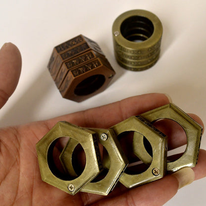 Brass hexagon rings held in an open palm with stacked hexagon rings blurred behind on a white background
