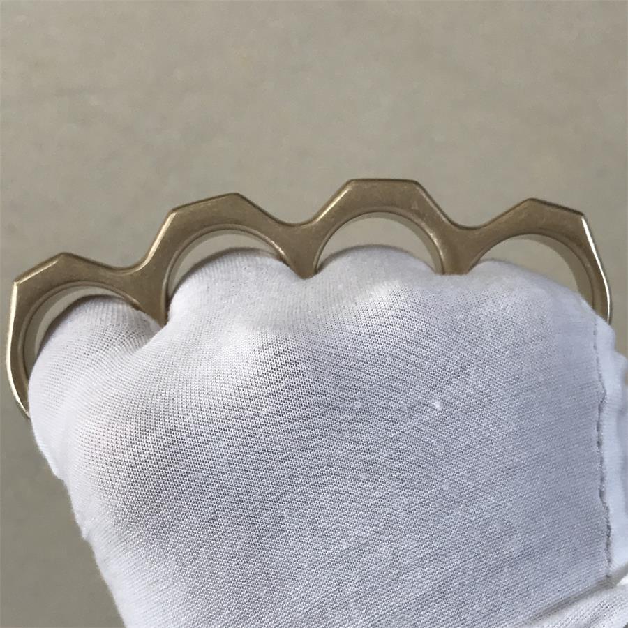 Brass knuckle duster worn on a gloved fist, showing the knuckle-side profile.