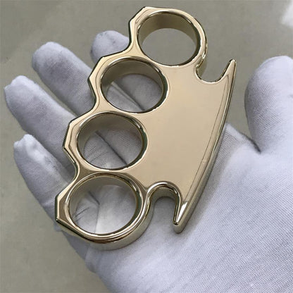 Brass knuckle duster laid across an open white gloved palm with the four finger holes facing up