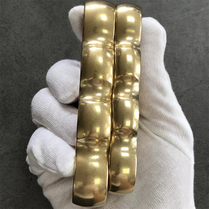 White-gloved hand holding the brass knuckle duster through the four finger holes