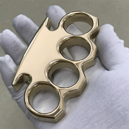 Mirror finish reflecting light across the surface of a brass knuckle duster in a gloved hand