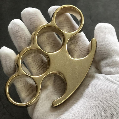 Open white-gloved palm holding the brass knuckle duster, wide smooth panel facing up