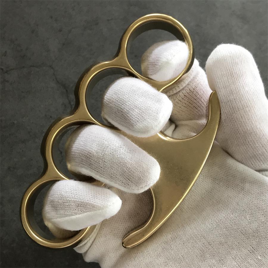 White-gloved fist wearing the brass knuckle duster, claw tip pointing past the little finger