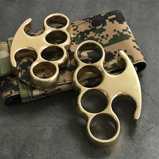 Large and Medium brass knuckle dusters resting on a camouflage fabric pouch