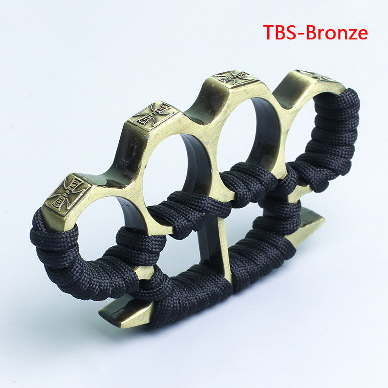 Bronze three-hole knuckle duster with black paracord grip on white background