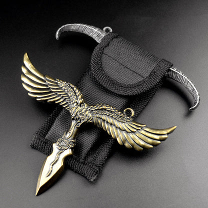 Bronze eagle pendant with spread wings and coiled snake detail beside a black nylon sheath and a silver gray horn piece on a dark background