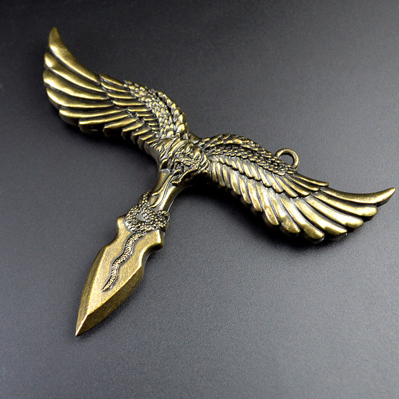 Close view of the bronze eagle pendant showing feathered wings, the hanging ring and the snake motif coiled on its dagger style point