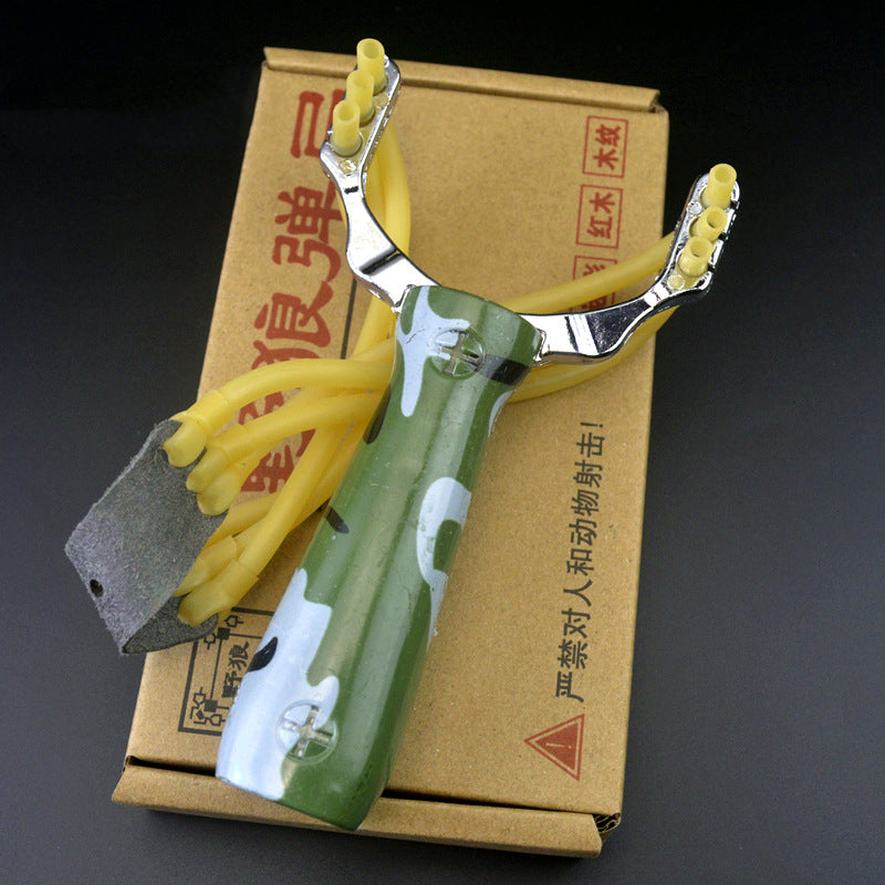 Camouflage slingshot lying on the printed cardboard box with yellow band strands and grey leather pouch