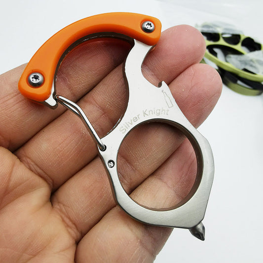 Steel carabiner keychain tool held in an open palm, orange handle scales with two screws, spring gate, Silver Knight engraving, large finger hole and pointed tip