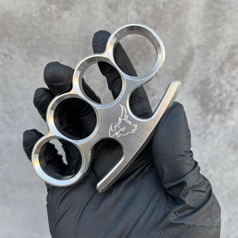 Black-gloved hand presents the 304 stainless steel classic knuckle duster in a relaxed hold.