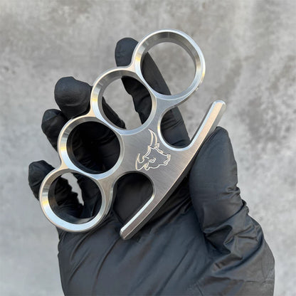 Black-gloved hand presents the 304 stainless steel classic knuckle duster in a relaxed hold.