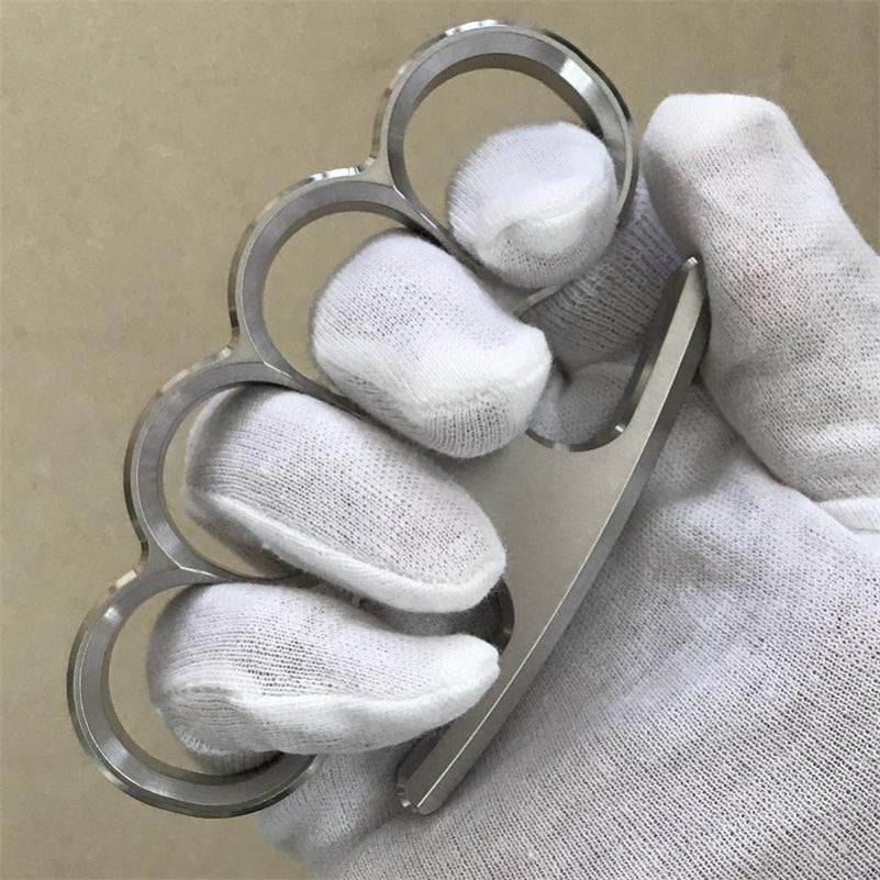 White-gloved fist grips the 304 stainless steel classic knuckle duster from the front.