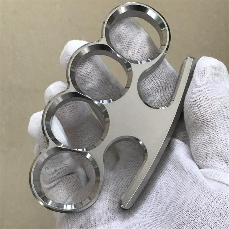White-gloved fist presents the 304 stainless steel classic knuckle duster toward the camera.