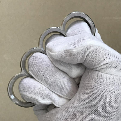 White-gloved fist wearing the 304 stainless steel classic knuckle duster, top-down view.