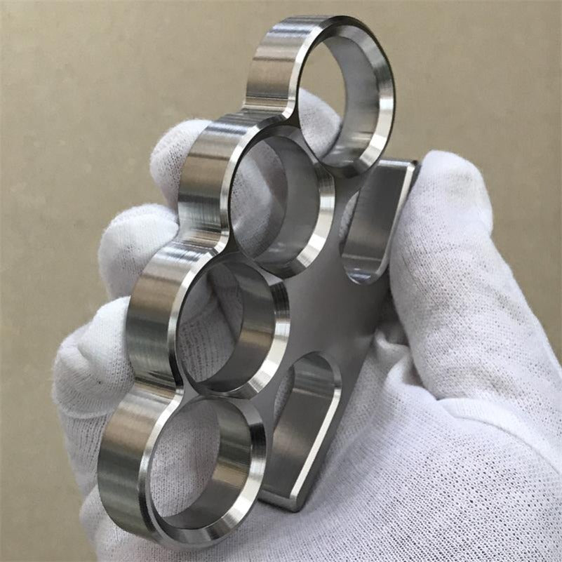 A white-gloved hand grips the 304 stainless steel classic knuckle duster to show finger hole fit.