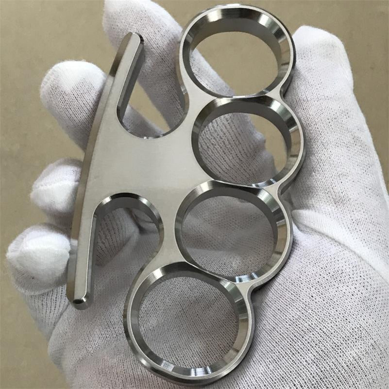 The 304 stainless steel classic knuckle duster held at a slight angle in a gloved grip.