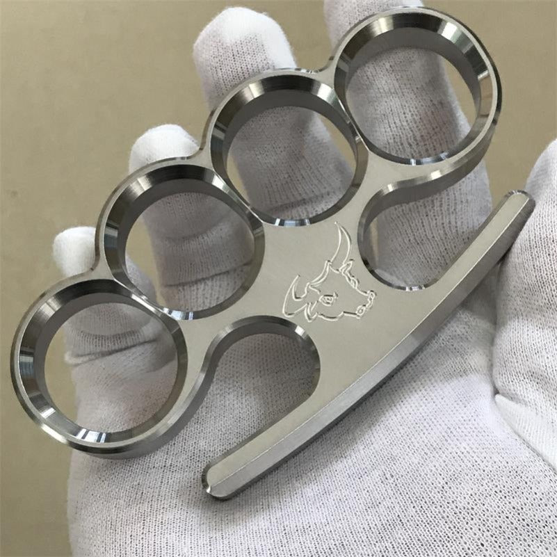 The 304 stainless steel classic multi-style knuckle duster rests in a white-gloved palm, showing the four finger holes from above.