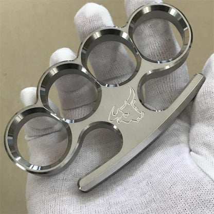 The 304 stainless steel classic multi-style knuckle duster rests in a white-gloved palm, showing the four finger holes from above.