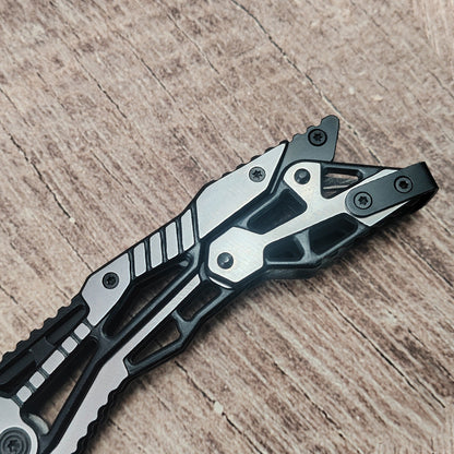 Closed all-steel mechanical folding knife showing skeleton handle on wood surface