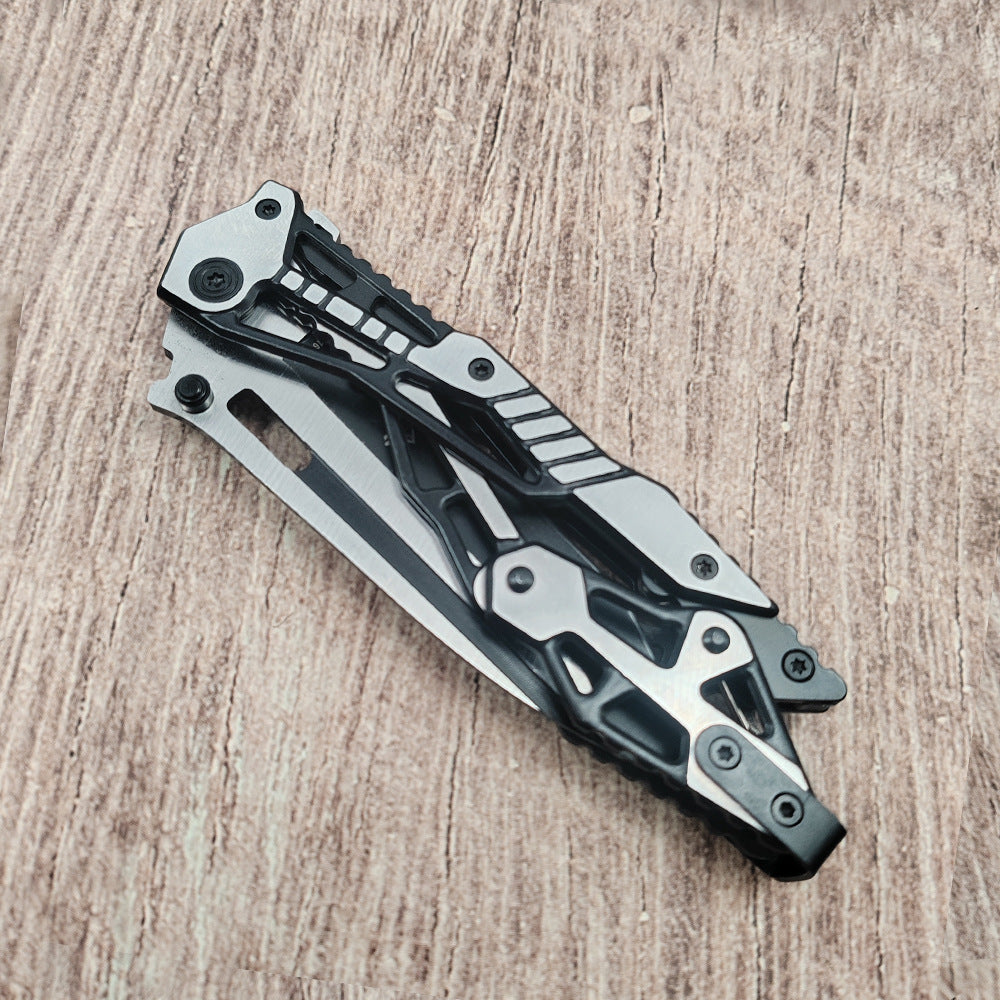 Closed all-black steel folding knife on wood surface