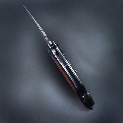 Closed folding knife side profile showing pocket clip on dark background
