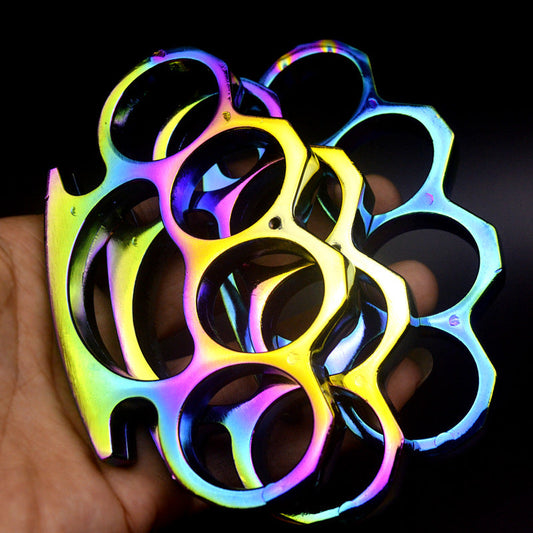 Iridescent dazzle colour four-hole knuckle dusters stacked in an open palm, purple, gold and green tones on a dark background