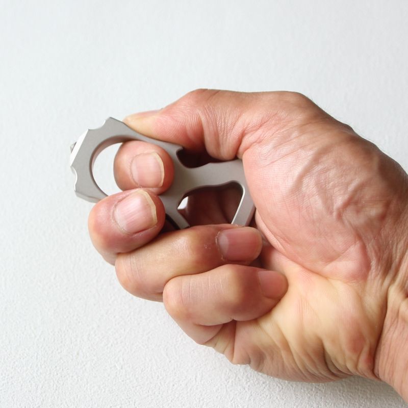 Hand gripping the stainless steel single-hole bottle opener duster to show fit.