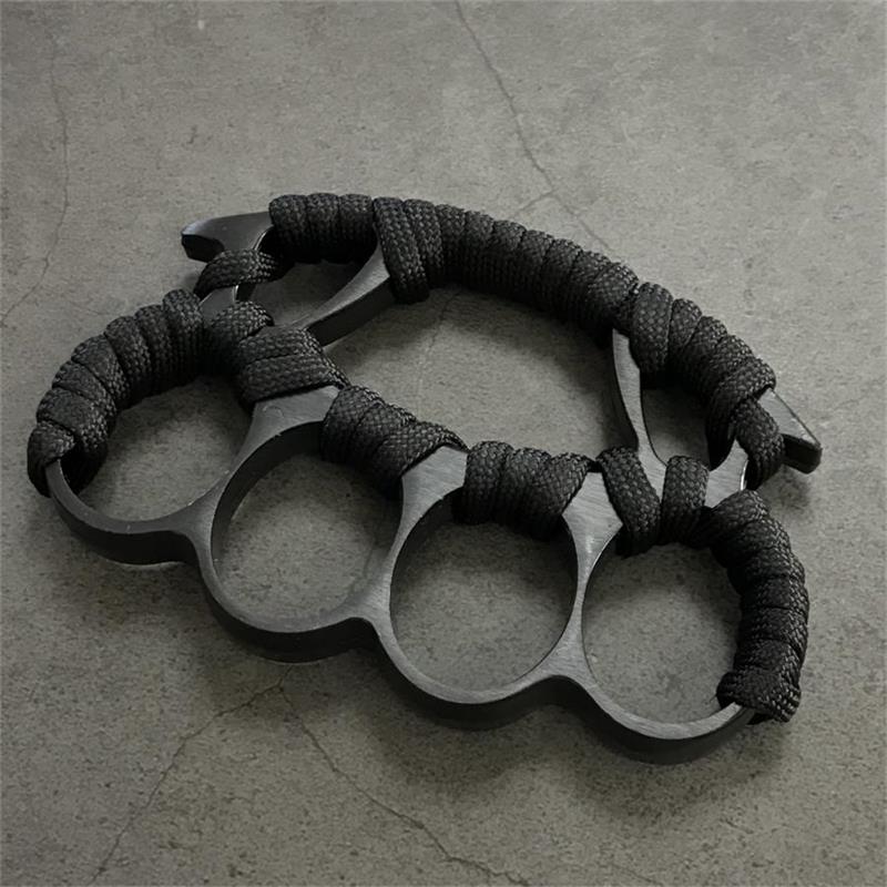 Two black knuckle dusters with paracord grips placed side by side