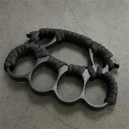 Two black knuckle dusters with paracord grips placed side by side
