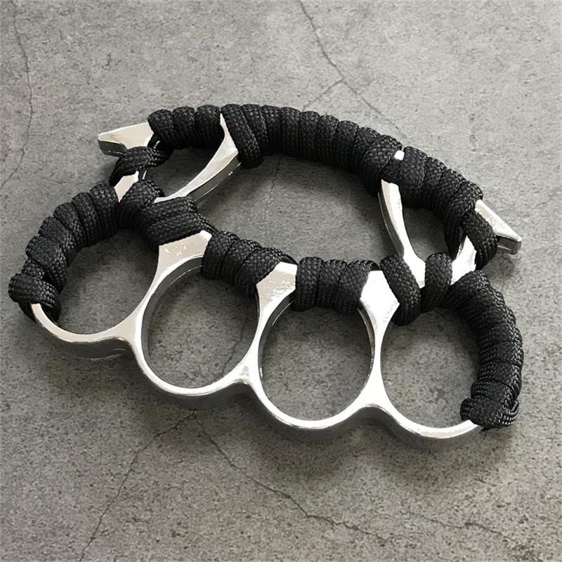 Silver knuckle duster with black paracord grip on dark background