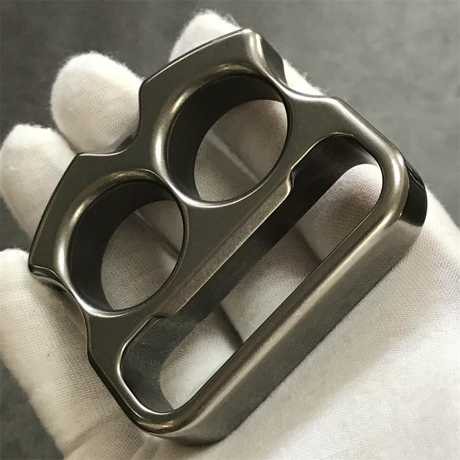 Gloved hand holding titanium duster face forward showing lower slot
