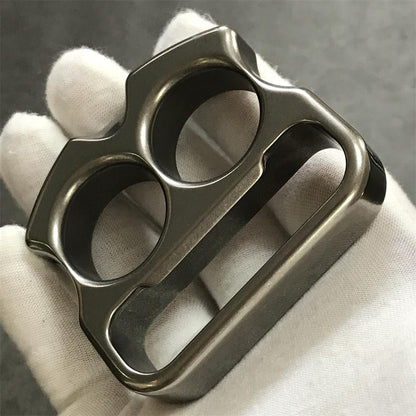 Gloved hand holding titanium duster face forward showing lower slot