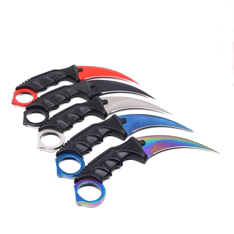 Five colorful one-hole karambit knives fanned out with black handles