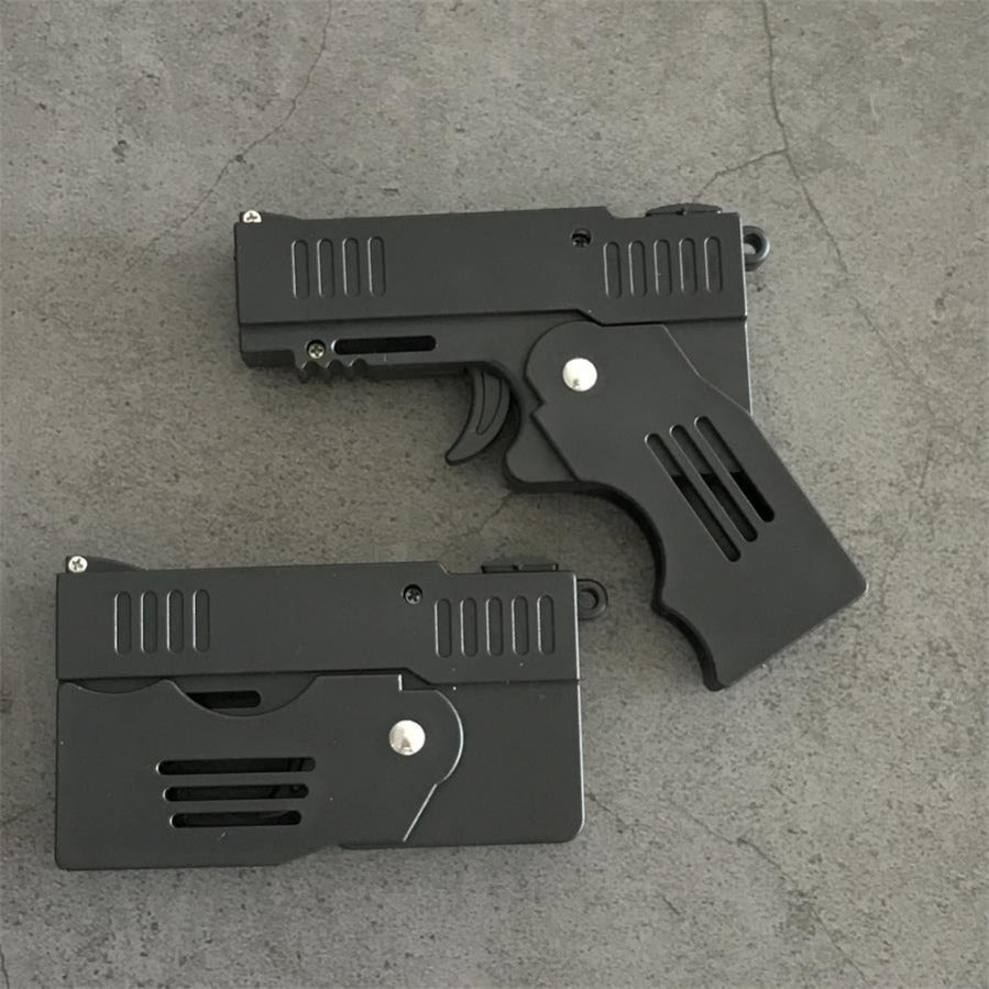 Folded stun gun lying at an angle with the silver hinge pin and ventilation slots visible on the matte black body