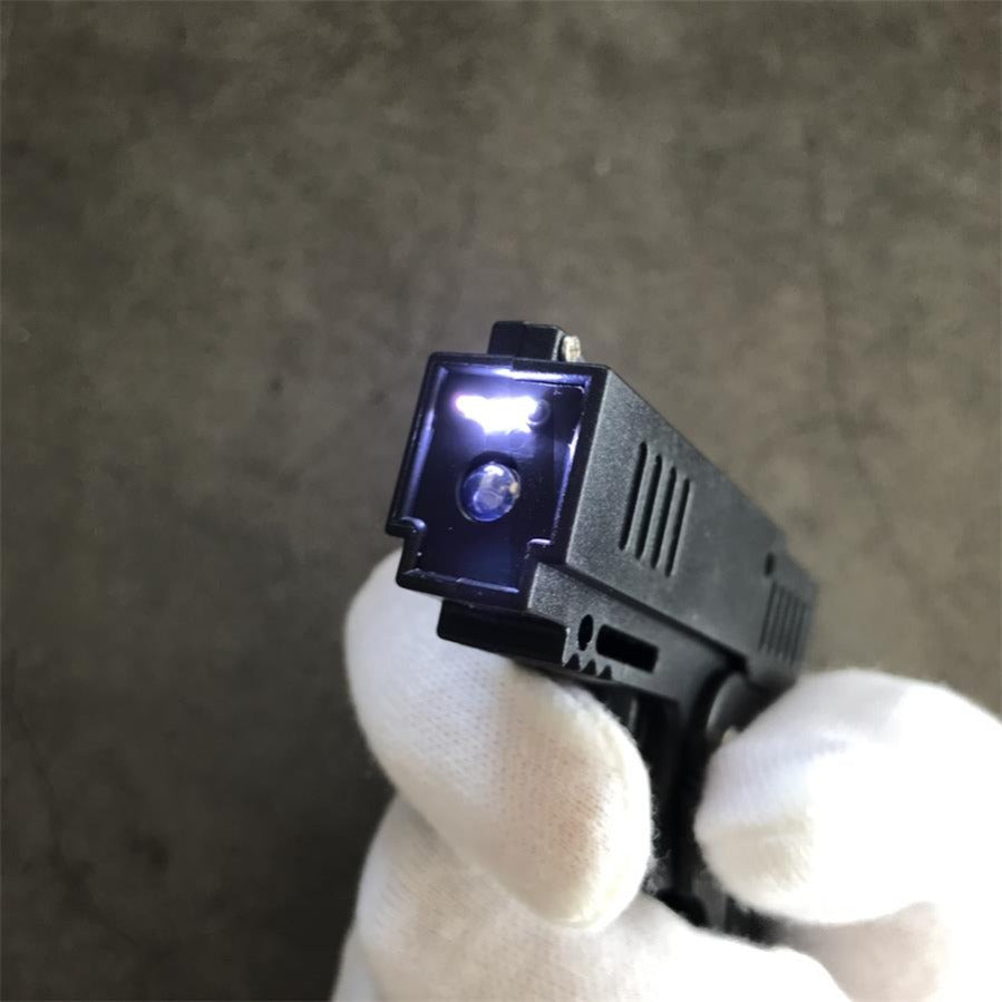 Close view of the stun gun front with the LED lamp lit above the round electrode, held in a gloved hand