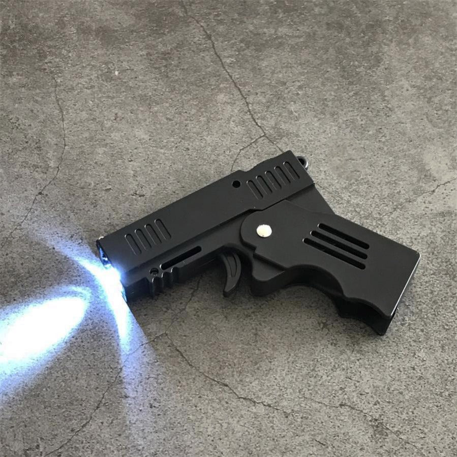 Unfolded stun gun on concrete with the front LED light casting a bright beam across the ground