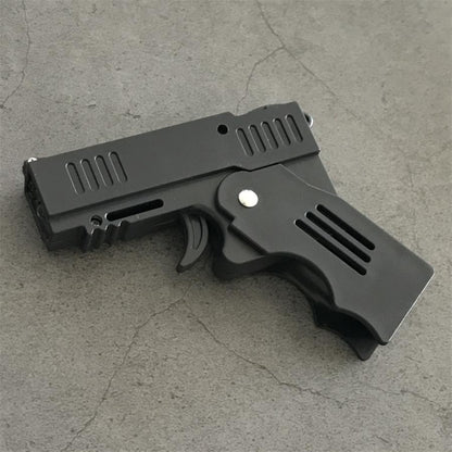 Front three-quarter view of the unfolded stun gun with the serrated muzzle end, trigger and hinge pin on concrete