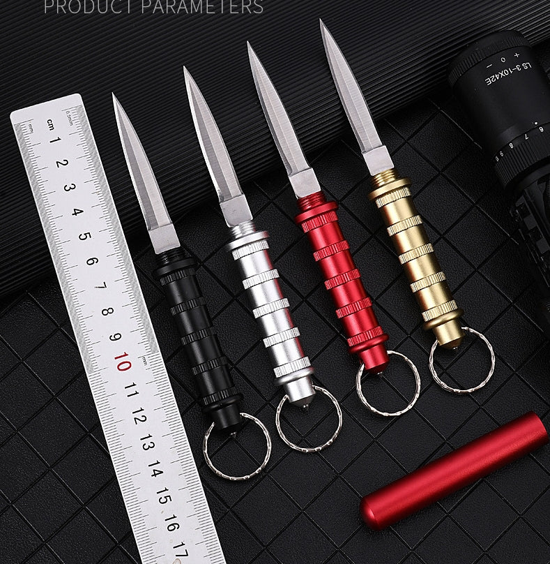 Four keychain daggers on a black grid with a white cm ruler for scale and a 'Product Parameters' label, a detached red sheath at the lower right.