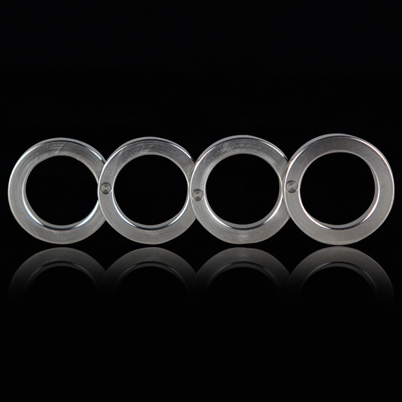 Front view of the four stainless steel rings unfolded in a row on a black background with a reflection below
