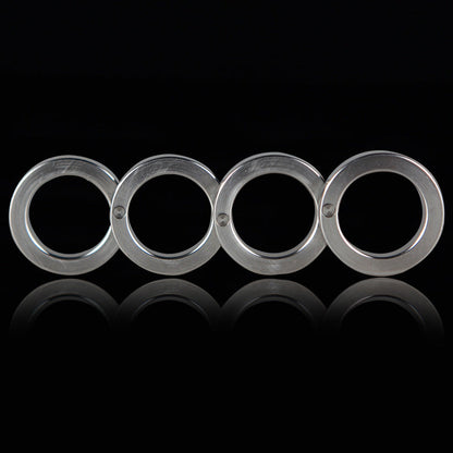 Front view of the four stainless steel rings unfolded in a row on a black background with a reflection below