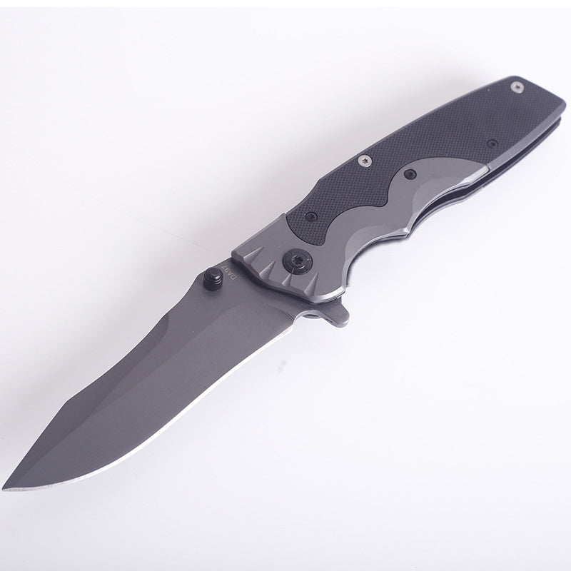 G10-handle folding knife open on a white surface, dark textured scales and gray blade in view