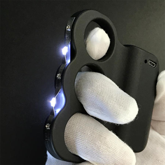 White-gloved hand gripping the black three-hole stun device with a bright electric arc jumping between the prongs, USB charging port on the top edge