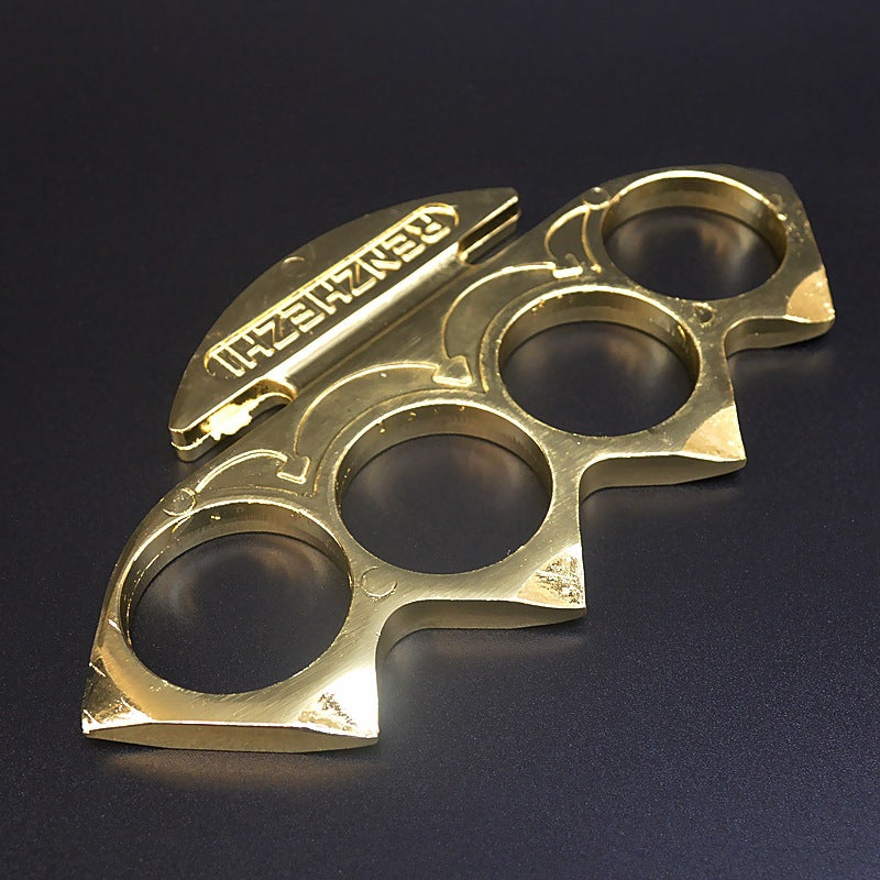 Gold knuckle duster lying flat showing the peaked shoulders and curved arrow engravings