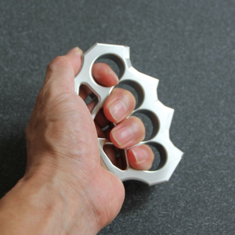 Hand holding the grass shaped stainless steel duster to demonstrate finger hole size.