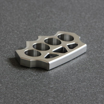 Low angled shot of the grass shaped stainless steel duster on dark surface.