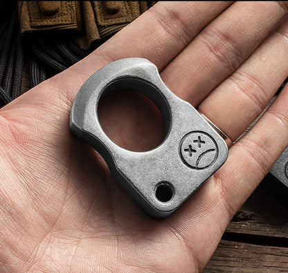 Gray single-hole knuckle weight front view on white showing the 25mm finger hole, the corner hole and the crossed-eye engraving