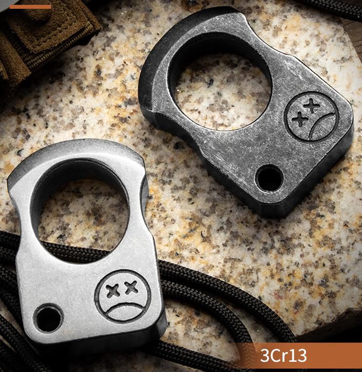 Gray single-hole knuckle weight held in a gloved hand showing the stone washed finish and the corner hole