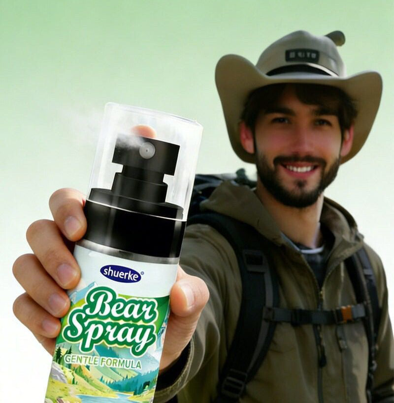 A smiling hiker in a khaki hat and green jacket holds up a white Bear Spray bottle with a black pump-action head and clear cap, a puff of mist above the nozzle, against a green background.