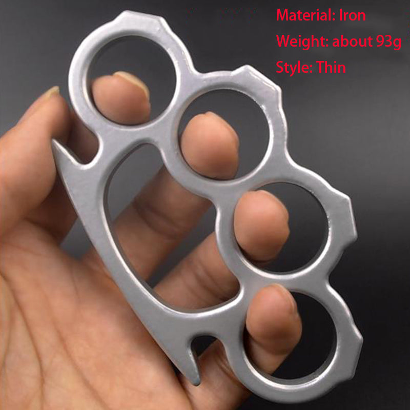 Silver thin iron knuckle duster held against a dark background with four round finger holes